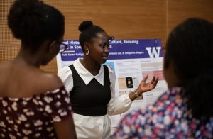 Ruth Nakigozi speaks with attendees at the Undergraduate Research Symposium.