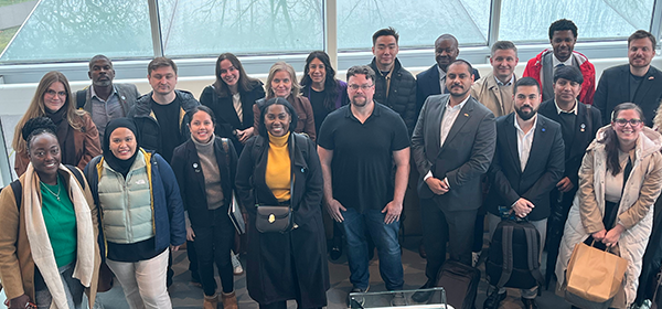 A group of leaders from around the world stand in the atrium of the School of Law.